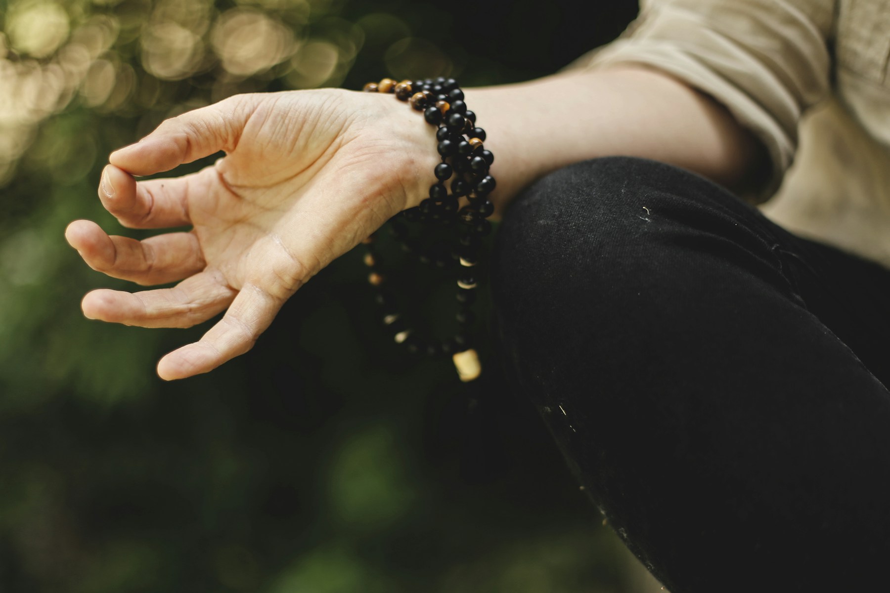 Person meditating outdoors in a quiet landscape